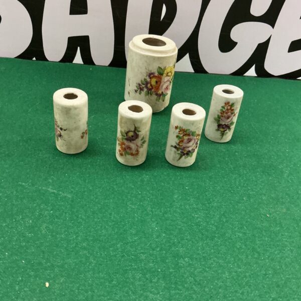 Antique porcelain toothbrush holder with floral design.