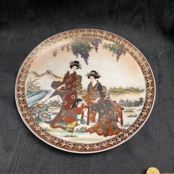 Antique Satsuma plate with geisha painting and gold accents.