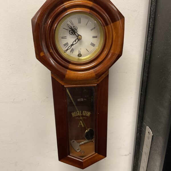 Antique wall clock regulator with striking mechanism and pendulum.