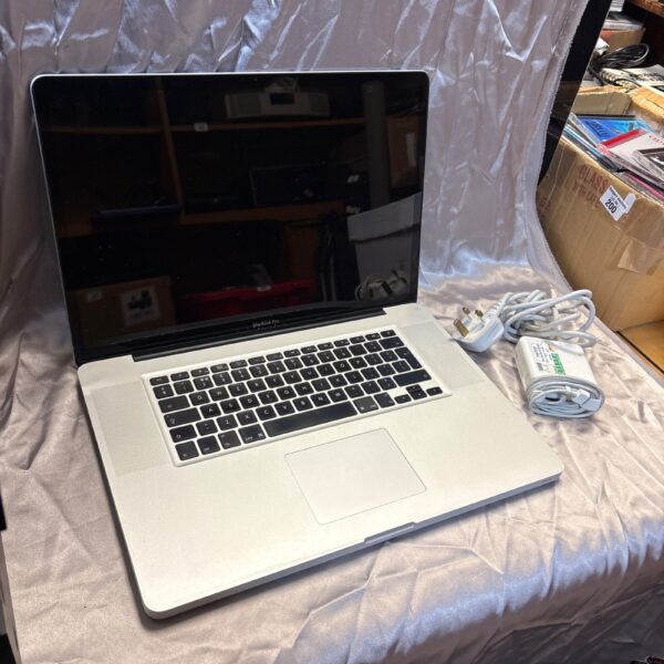 Silver Apple MacBook Pro laptop with charger, model A1297.