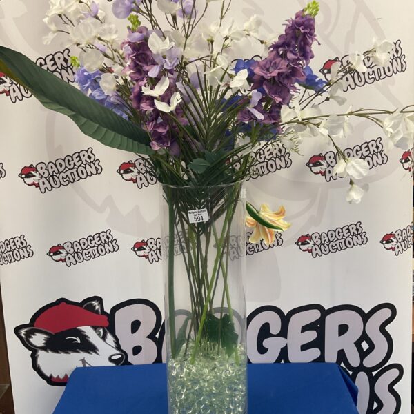 Vibrant artificial flower arrangement in a clear glass vase.