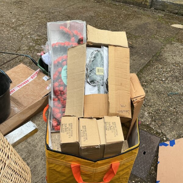 Large bulk lot of colourful artificial flowers in a bag.