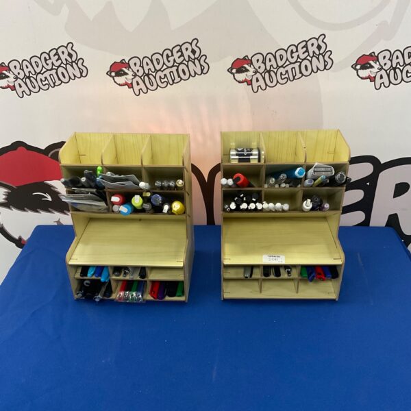 Wooden artist pen storage units filled with pens and art supplies.
