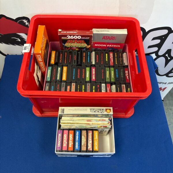 Large lot of vintage Atari 2600 video game cartridges in a red container.