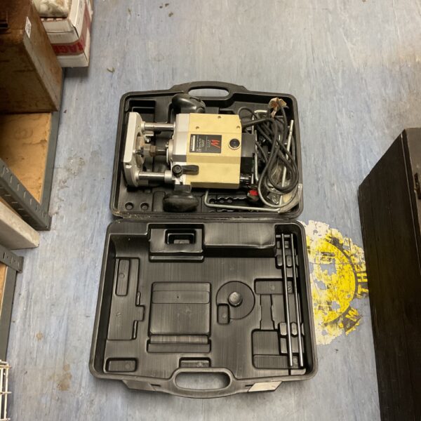 Axminster variable speed plunge router inside its carrying case.