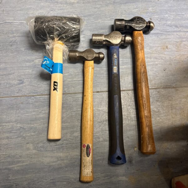 Lot of three ball peen hammers and mallet for metalworking.