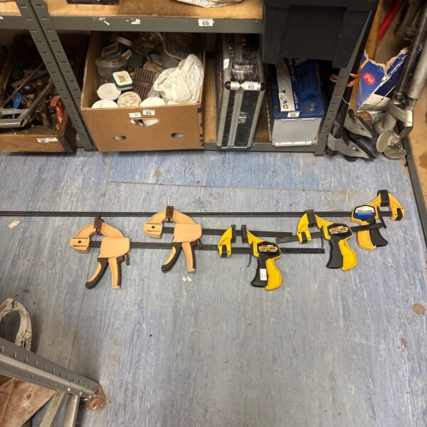 Metal bar clamps with quick grip handles for woodworking projects.