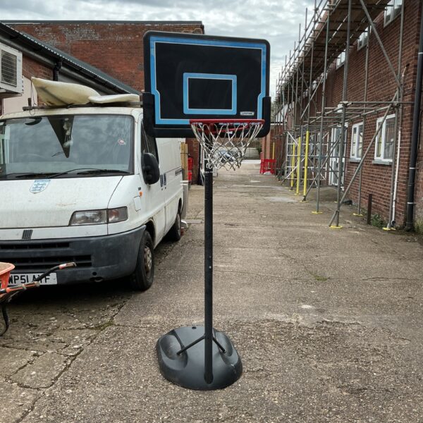 Portable basketball hoop and stand in an outdoor setting.
