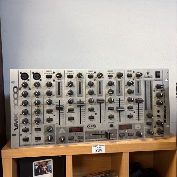 Behringer VMX1000 DJ mixer with multiple channels and controls.