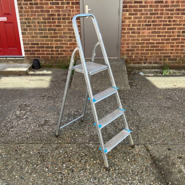 Silver Beldray aluminium step ladder against a brick wall.