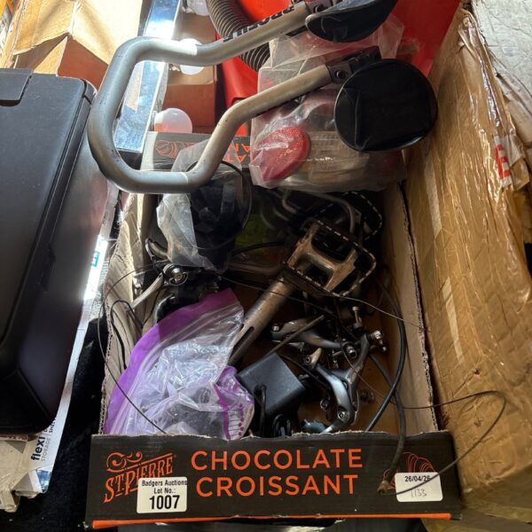 Assorted bike parts and accessories in a cardboard box.