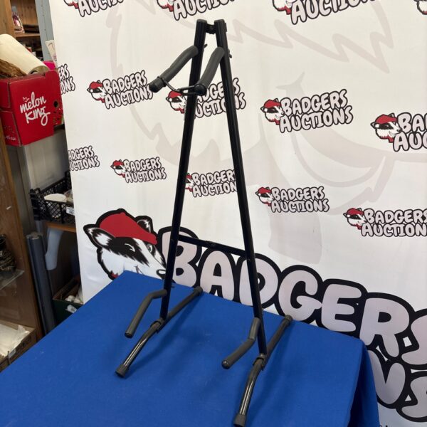 Black collapsible guitar stand for acoustic or electric guitars.
