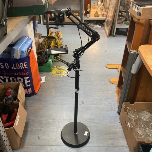 Black floor-standing microphone boom stand for recording.