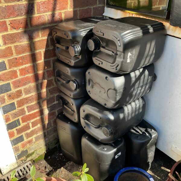 Lot of ten empty black plastic containers for storage.
