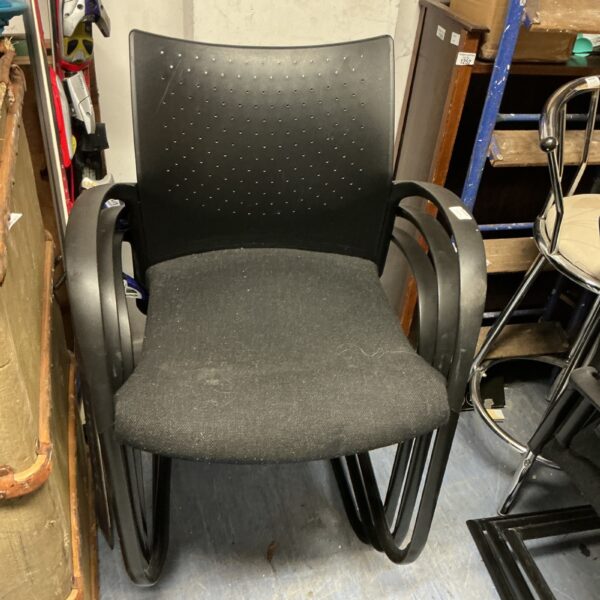 Black padded stacking chair, modern office seating.