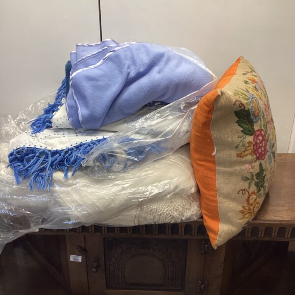 Colourful blankets and a tapestry cushion in a vintage lot.