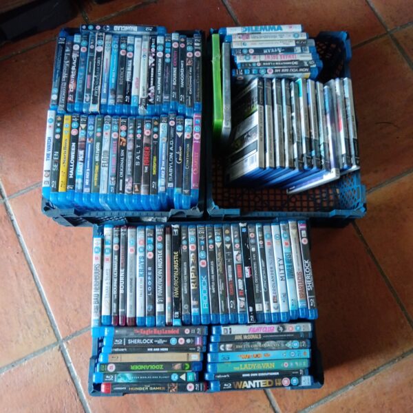 Blu-Ray and Playstation game lot with multiple trays of discs.