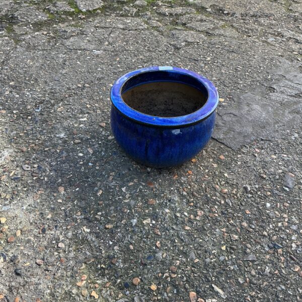 Vibrant blue glazed garden planter for outdoor plants.