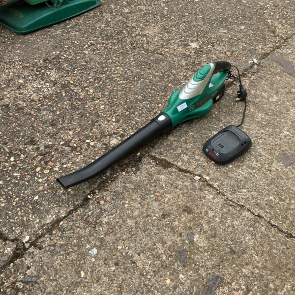 Bosch battery leaf blower with charger for garden use.