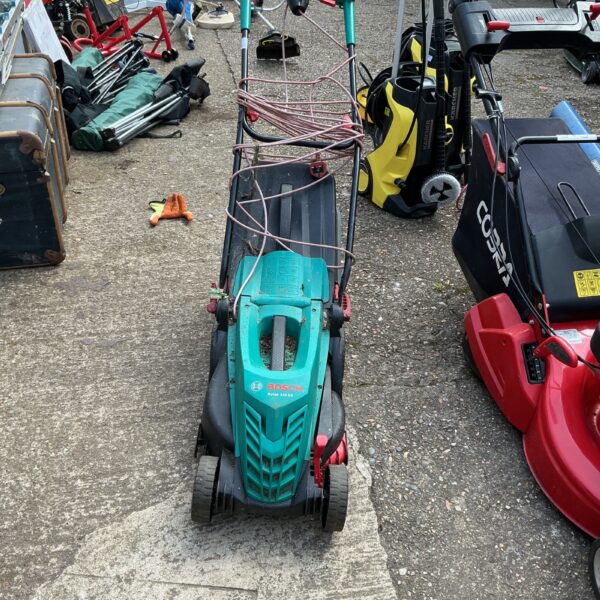 Used Bosch electric lawnmower in a garden setting.
