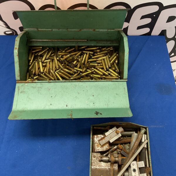 Green toolbox filled with spent brass rifle cartridges and engineers tools.