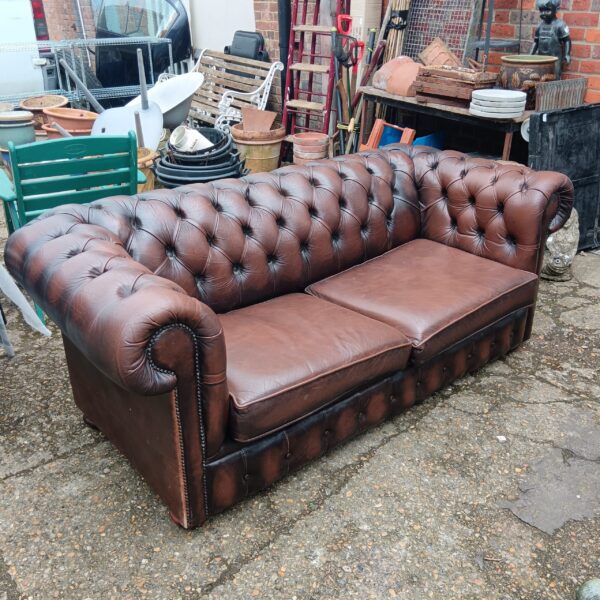 Vintage brown leather chesterfield sofa with buttoned detail.