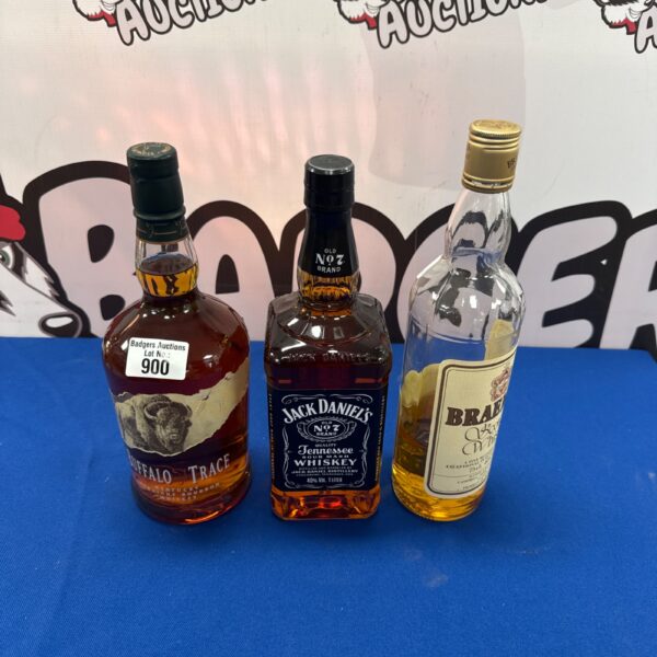 Sealed bottles of Buffalo Trace bourbon, Jack Daniels, and Braemar whisky.