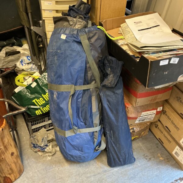 Rolled camping tent secured with straps in a carry bag.