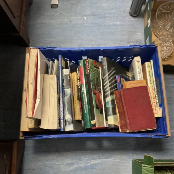 Stack of vintage car books, including Porsche titles.