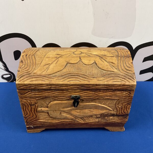 Intricately carved wooden chest with a rustic folk art design.