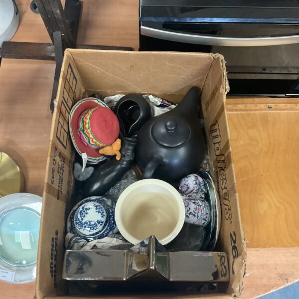 Vintage ceramic teapot and cutlery collection on display.