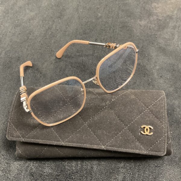 Pale pink Chanel reading glasses with quilted black case.
