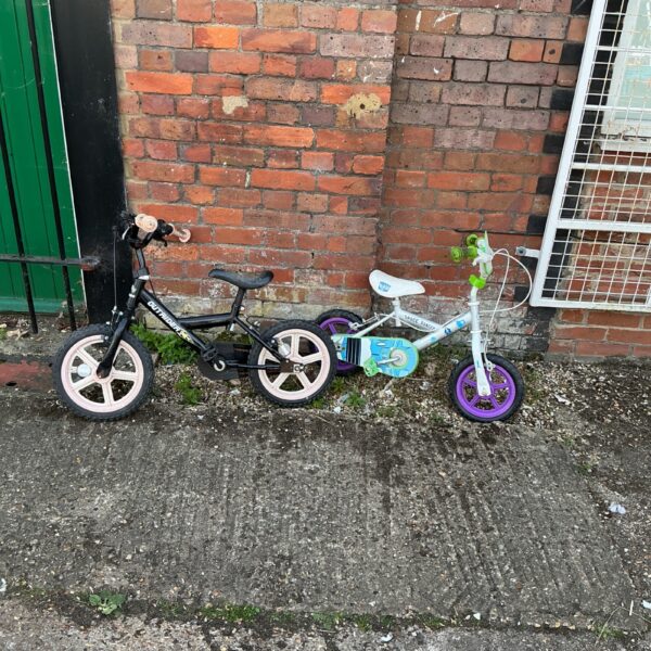 Two children’s bikes, purple and blue, for outdoor play.