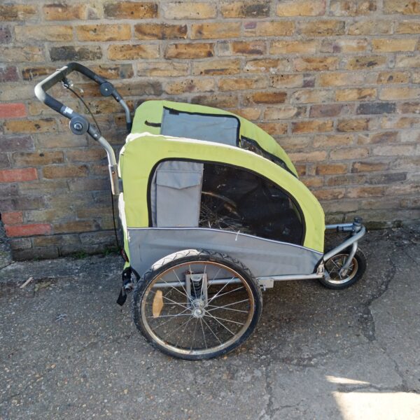 Green and grey child's bike trailer for cycling with kids.