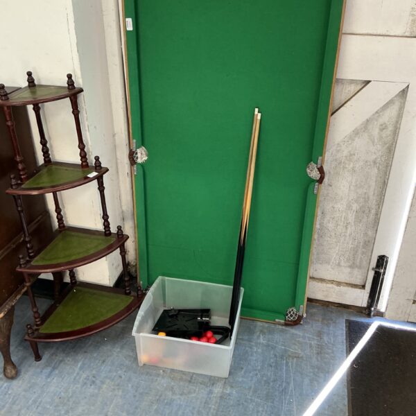 Child’s snooker table with cues and coloured balls on display.