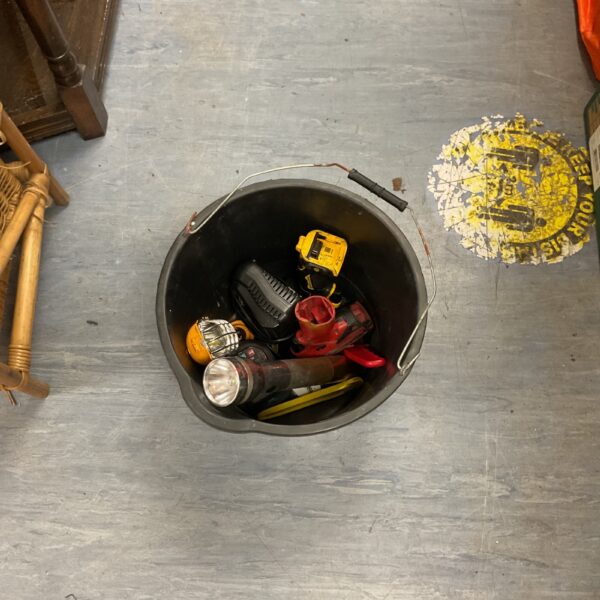 Mixed lot of cordless power tool components and flashlights in a bin.