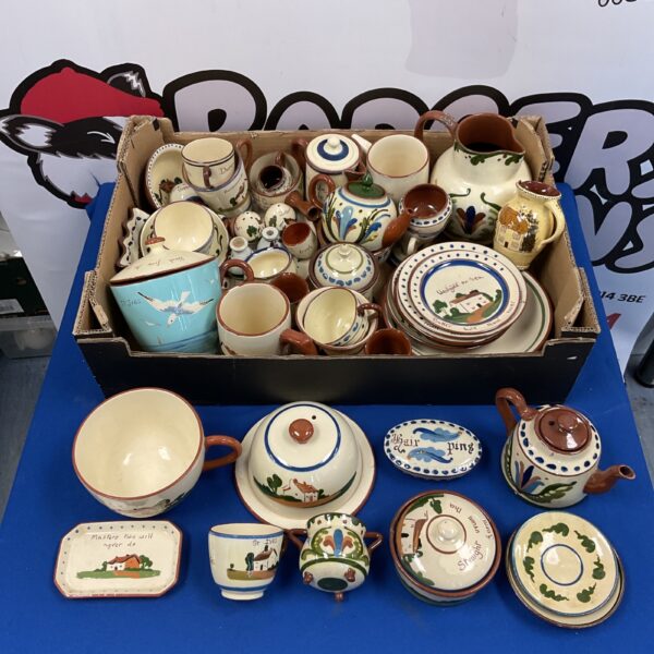 Vintage Cornish Ware pottery collection featuring colourful teapots and jugs.