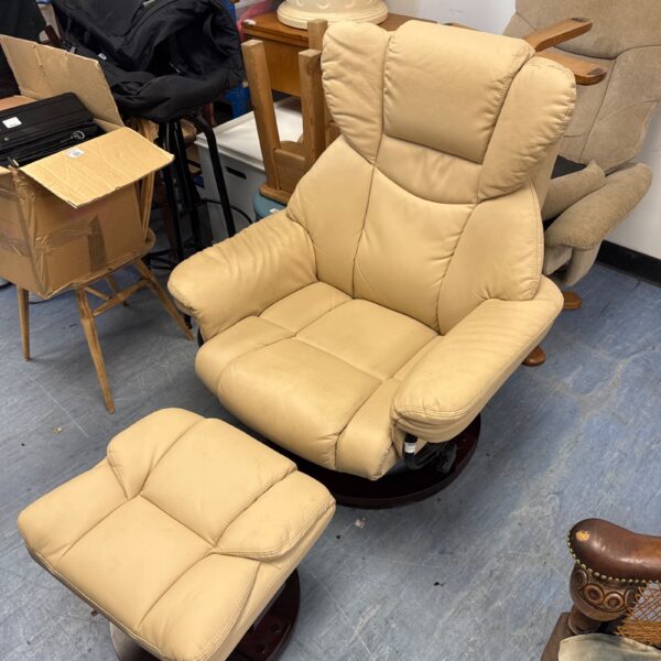 Cream leather recliner chair with matching footstool for comfortable seating.