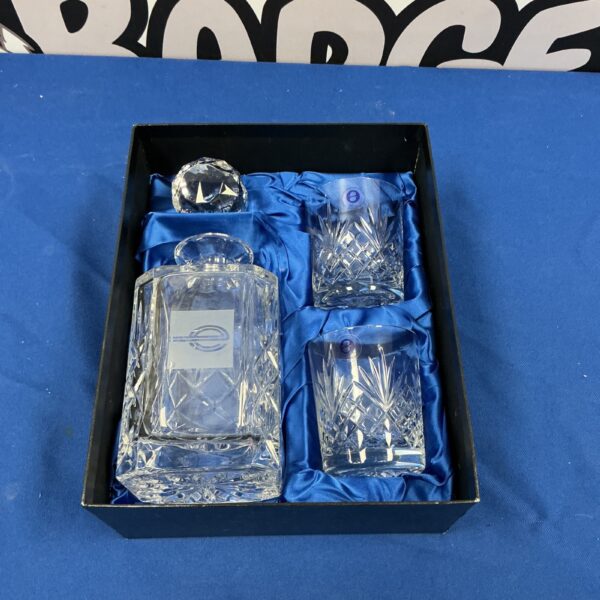 Elegant crystal decanter set with matching tumblers for serving spirits.