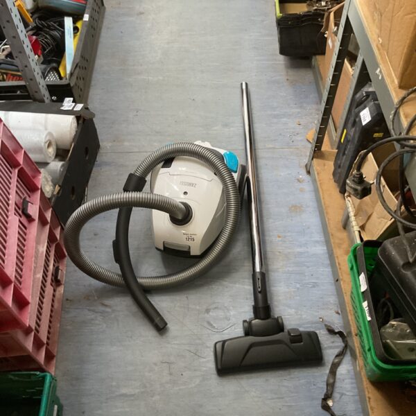 Vintage cylinder vacuum cleaner with hose and floor head.