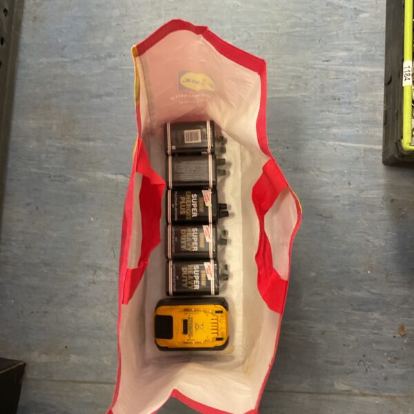 Dewalt 54V Flexvolt battery pack and lantern batteries in a yellow bag.
