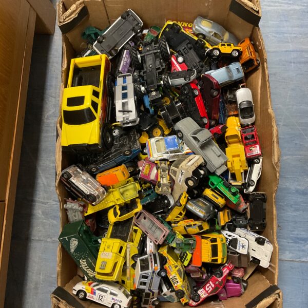 Assorted diecast model cars in a cardboard box.