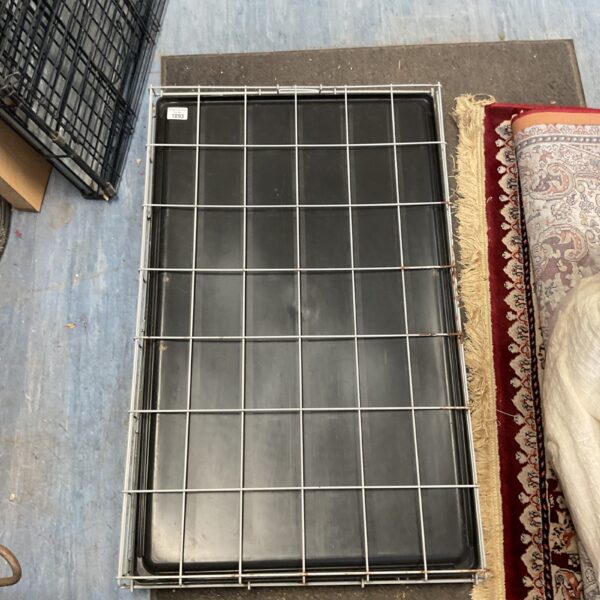 Foldable metal wire dog crate with plastic tray for pet transport.
