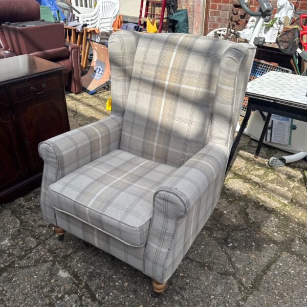 Comfortable chequer pattern armchair on casters for living room use.
