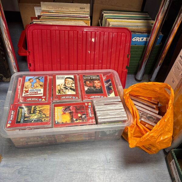 Red plastic container filled with a large DVD movie lot.