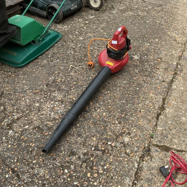 Front view of a used electric leaf blower for garden cleanup.