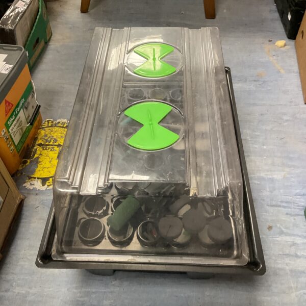 Electric seed propagator with green heating mat and seed tray.