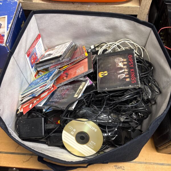 Mixed lot of electronics, chargers, and CDs for collectors.