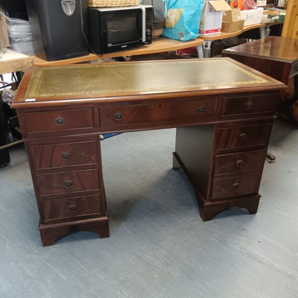 Mahogany executive desk with leather top and pedestal drawers.
