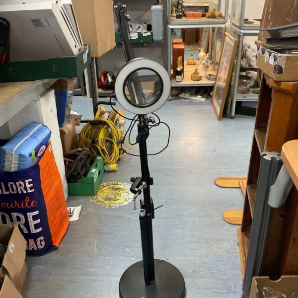 Adjustable floor magnifying lamp for detailed work and reading.